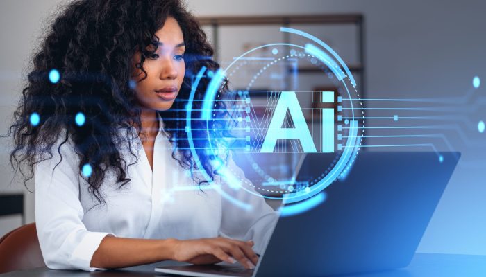 Portrait of beautiful young African American businesswoman using laptop in blurry office with double exposure of futuristic AI artificial intelligence interface. Concept of machine learning